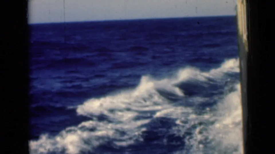 Home-movie frame from the 1946 Suez Canal area showing rolling blue water and white wake foam from a moving ship.