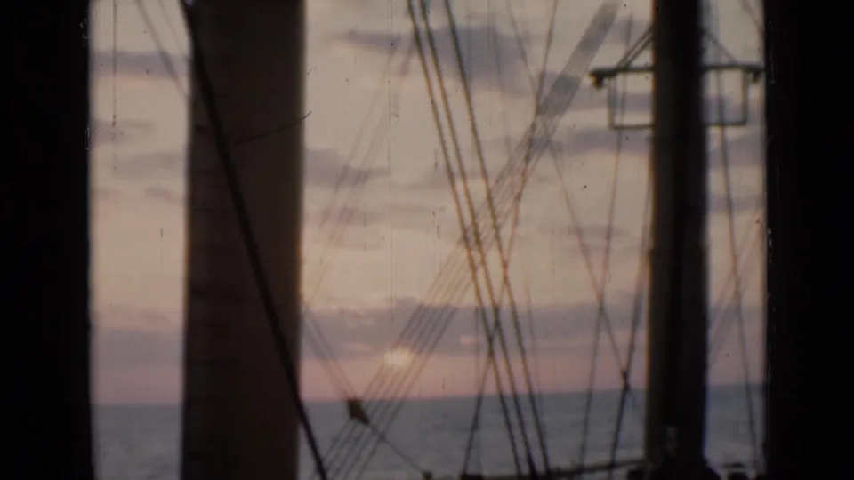 1946 shipboard sunset view near the Suez Canal context, with the sun low on the horizon behind silhouetted mast and rigging lines.