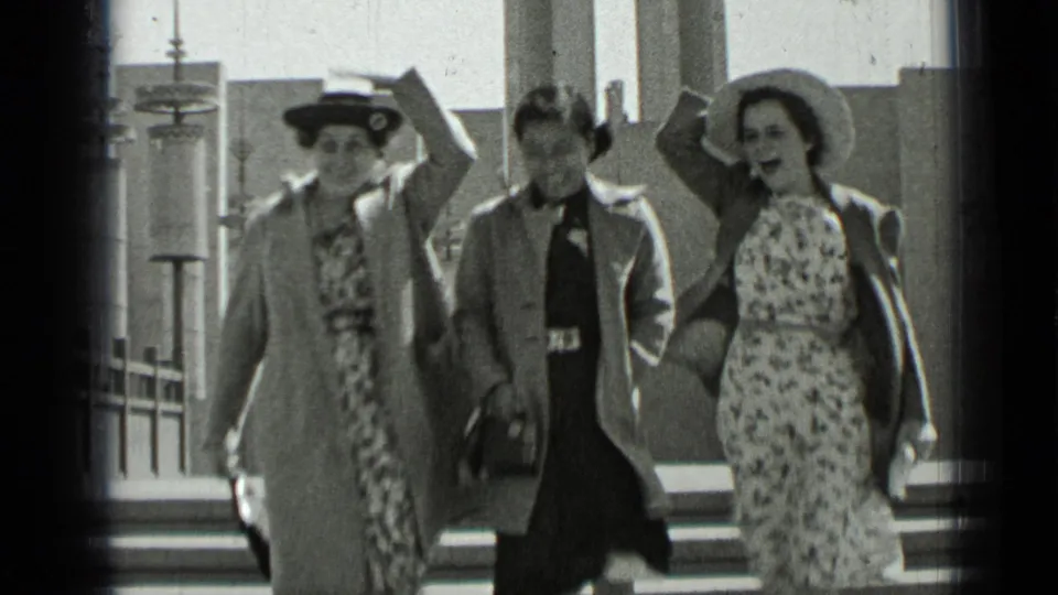 In 1937 San Francisco footage, three women in dresses, hats, and coats descend exterior church steps toward the camera.