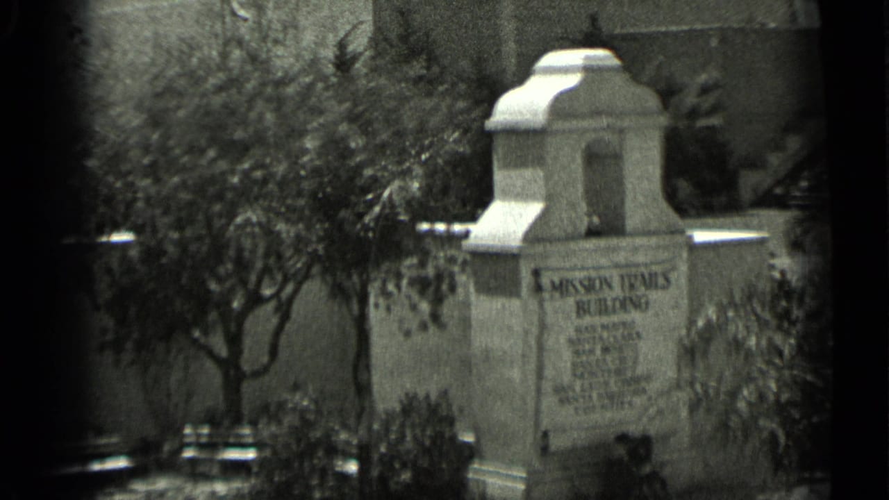 1937 San Francisco home-movie frame showing a stone Mission Trails Building sign with trees, shrubs, and soft film borders.