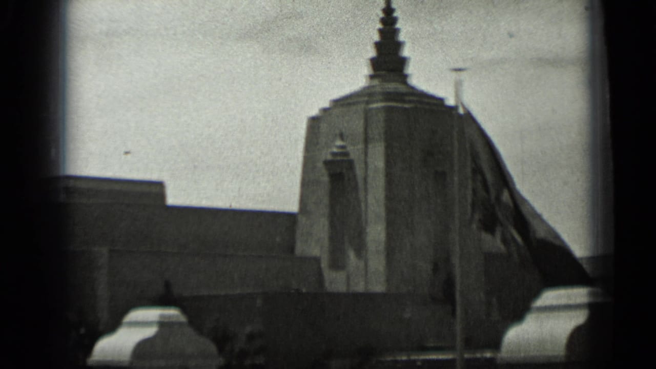 Stepped building tower with flagpole and dark flag in front.