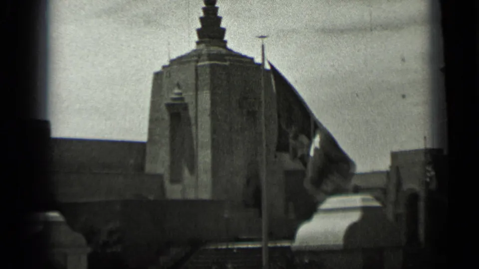 1937 San Francisco home-movie frame with the Mission Trails Building tower partly framed by a crescent-and-star flag.
