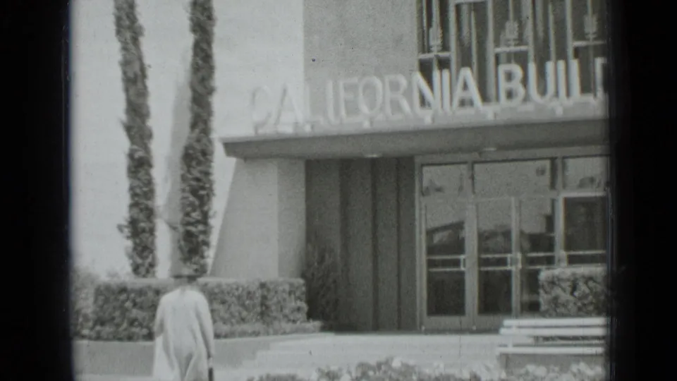 Exterior view of a San Francisco building entrance with a partial California sign and a person seen from behind.