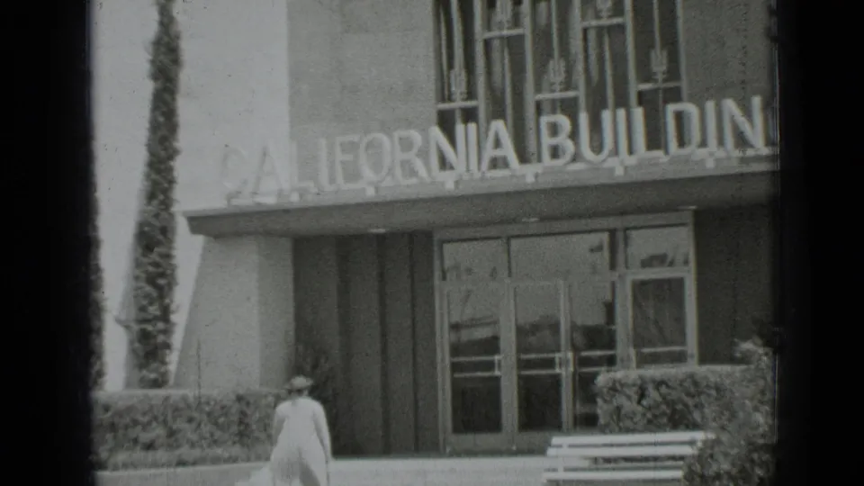 Closer 1937 San Francisco 8mm view of the California Building entrance, with the woman walking into the lower part of the frame.