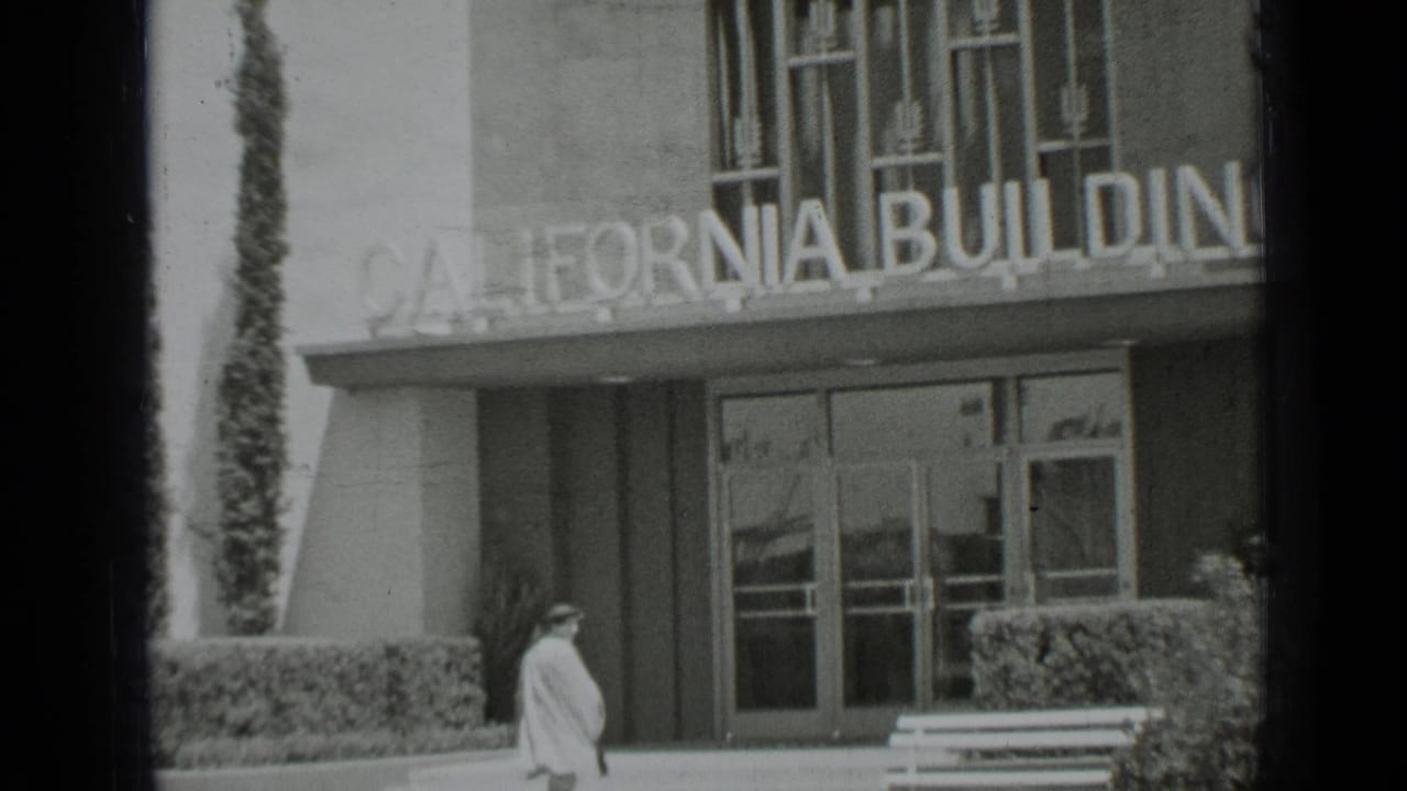 1937 San Francisco home-movie frame showing the woman near the California Building entrance beneath the large sign.