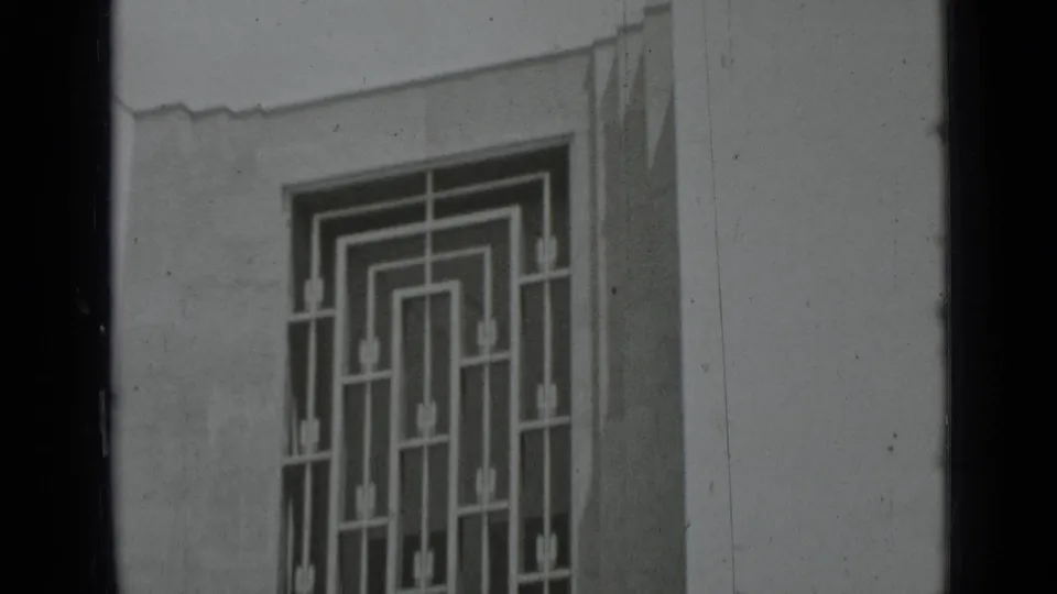 Black-and-white frame of a geometric window grille and pale exterior wall, consistent with the supplied 1937 San Francisco clip metadata.