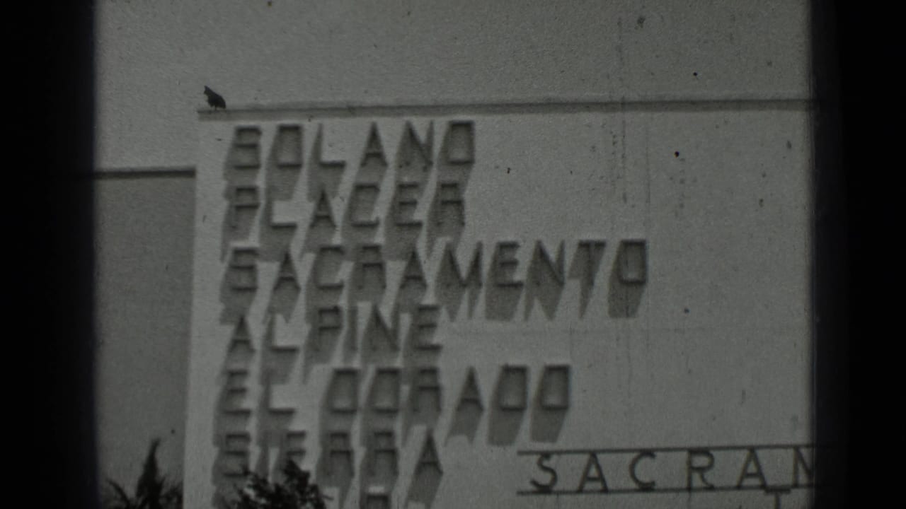Black-and-white frame of raised facade lettering with California place names, including a partial Sacramento inscription.