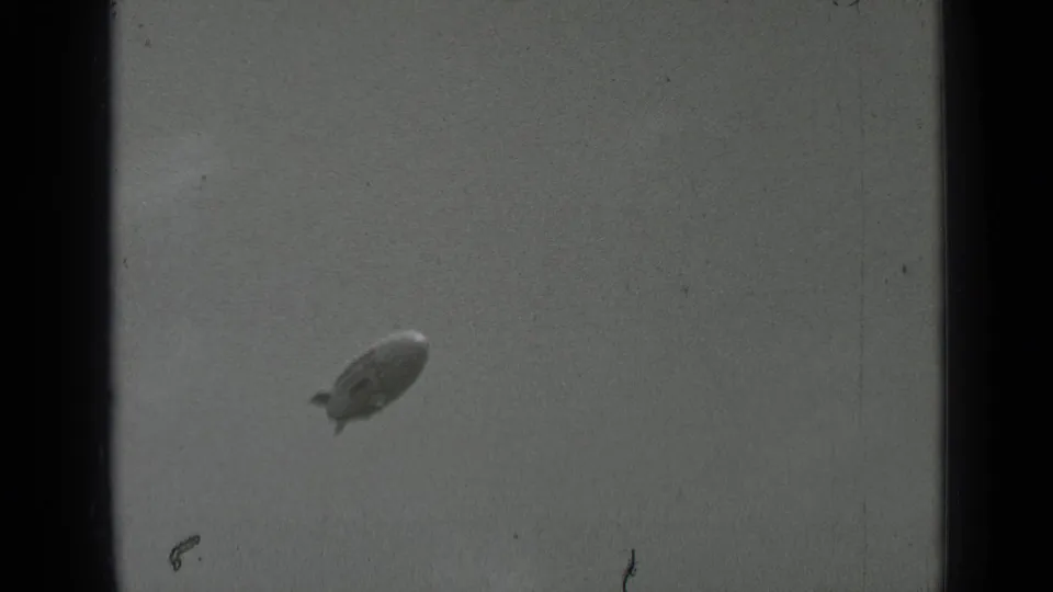 A Goodyear blimp appears at a distance in cloudy 1937 San Francisco 8mm footage, with visible grain and frame edges.