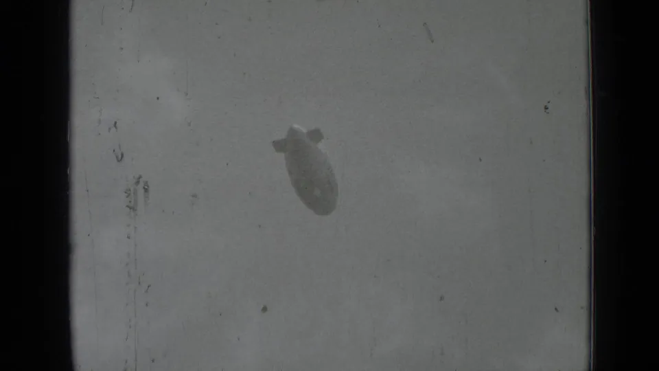Goodyear advertising blimp is faintly visible in a scratched 1937 home-movie frame over San Francisco.