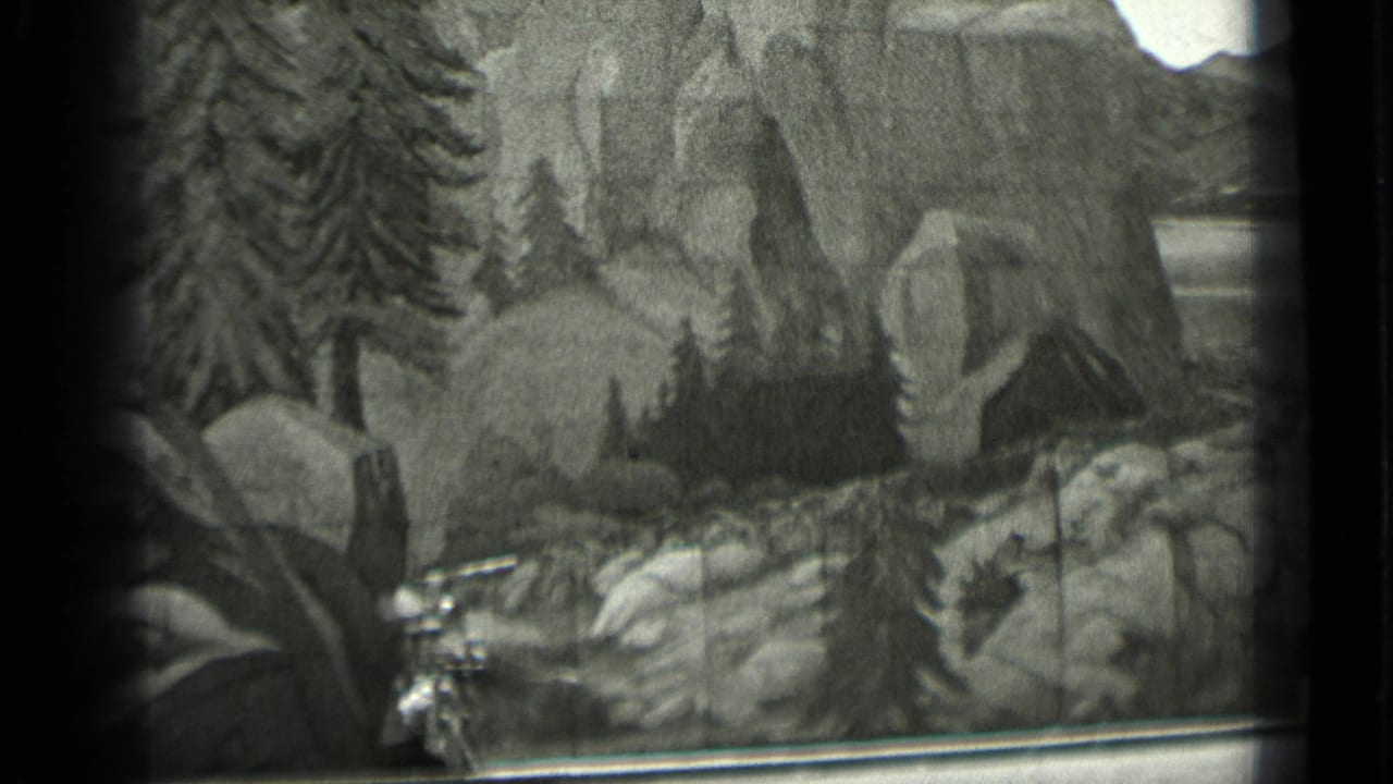 1937 San Francisco 8mm frame showing a miniature rocky landscape with pine trees, painted cliffs, and visible film-frame edges.