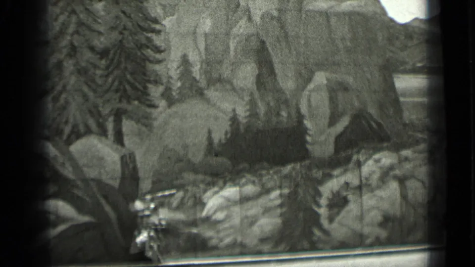 1937 San Francisco 8mm frame showing a miniature rocky landscape with pine trees, painted cliffs, and visible film-frame edges.