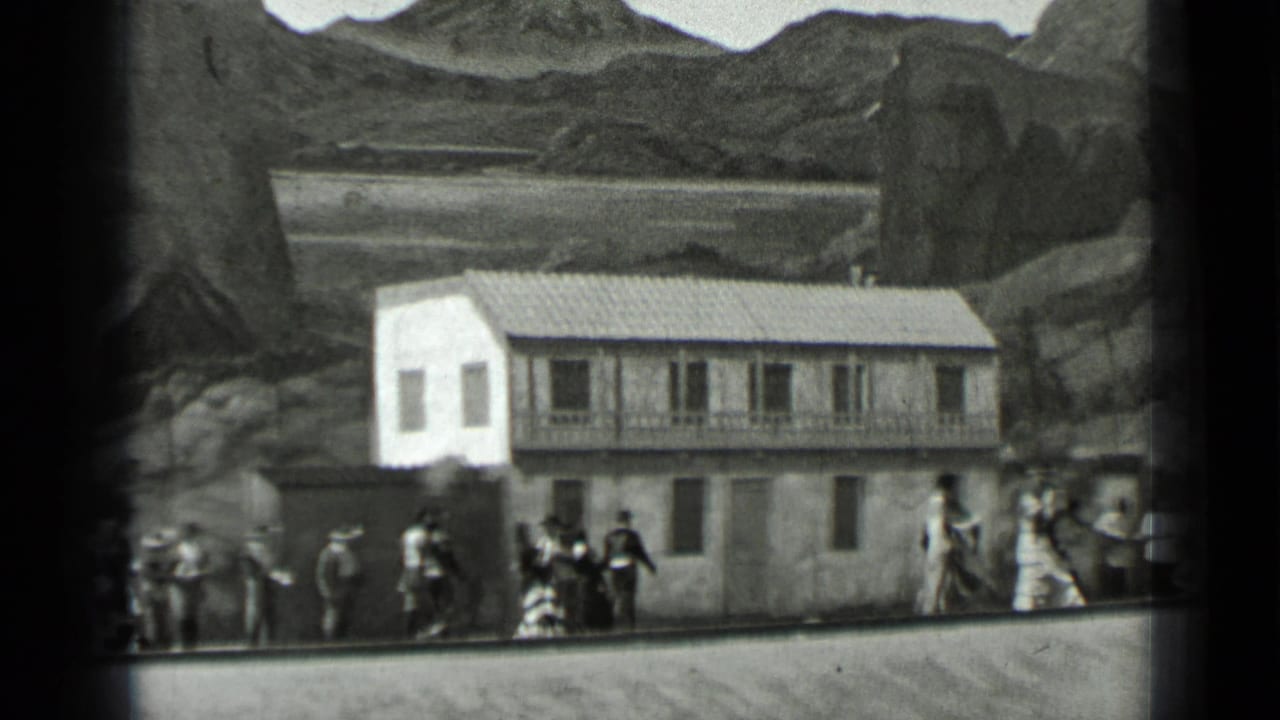 Costumed figures stand and move near a two-story facade with painted mountains behind it.