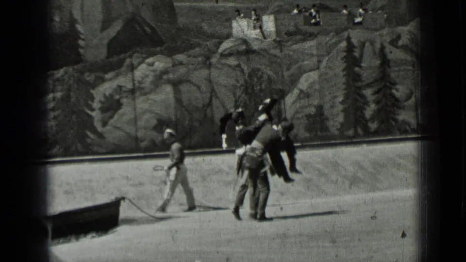 1937 San Francisco home-movie frame of adults walking across a staged-looking foreground near a low cart.