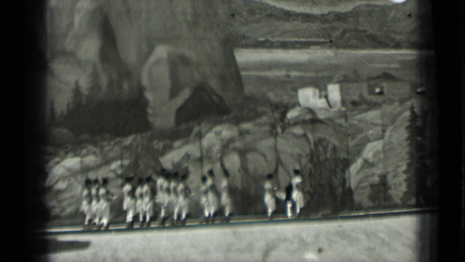 1937 San Francisco frame with a formation of light-uniformed people marching onstage in front of a mountain scene backdrop.
