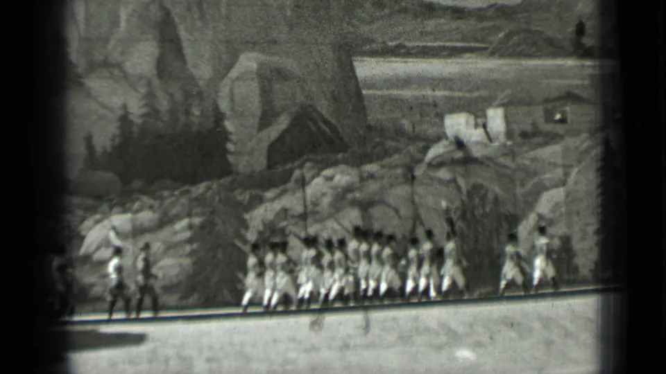Black-and-white 8mm frame from 1937 San Francisco showing uniformed marchers crossing a stage below a painted mountain backdrop.