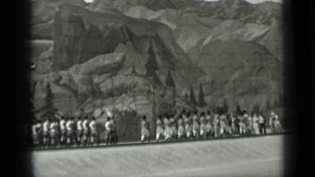 A larger group of costumed performers stands across a Western stage scene.