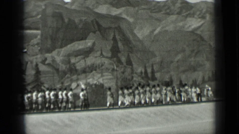 1937 San Francisco home-movie frame with a wide line of performers in Western and Native American-inspired costumes before scenic mountains.