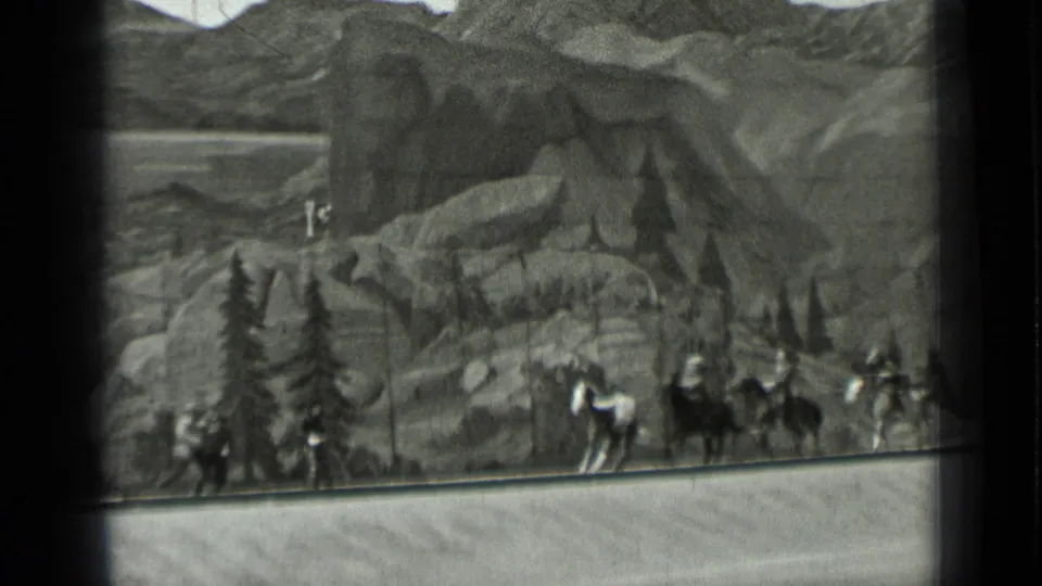 1937 San Francisco 8mm frame showing horses, riders, and costumed figures within a staged Western mountain setting.