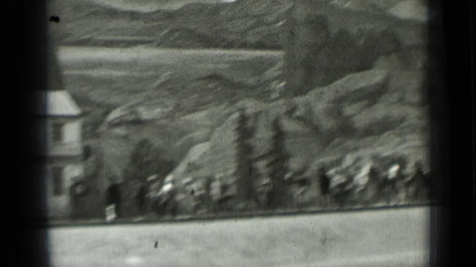 1937 San Francisco home-movie frame showing distant horseback riders and workers near rocky terrain and a small structure.