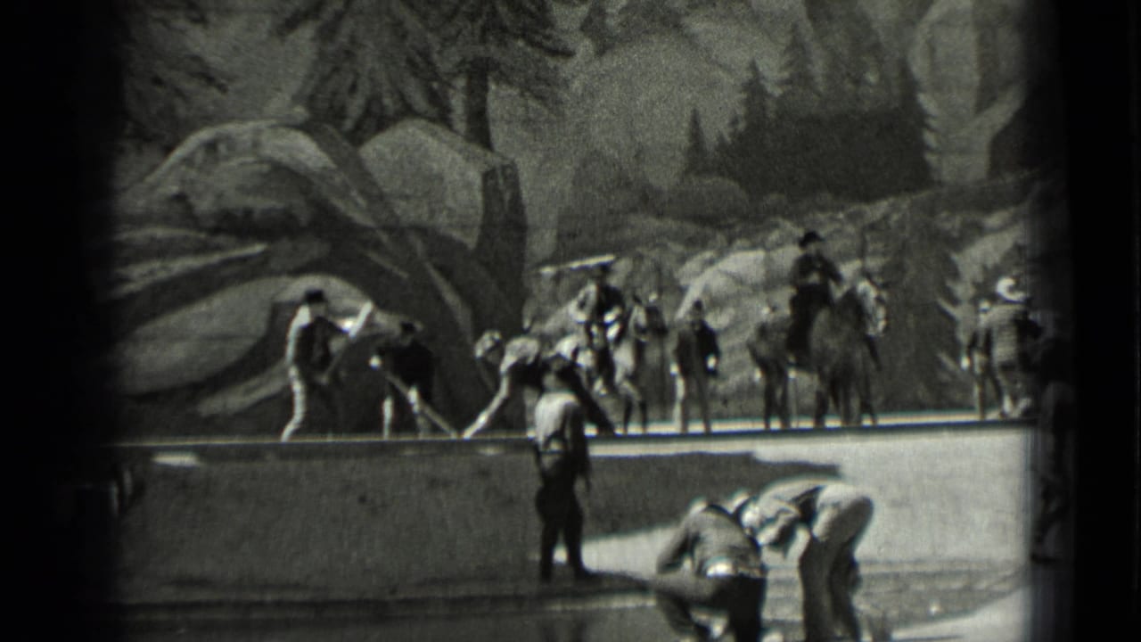 Horseback riders and workers gathered beside a low wall or edge.