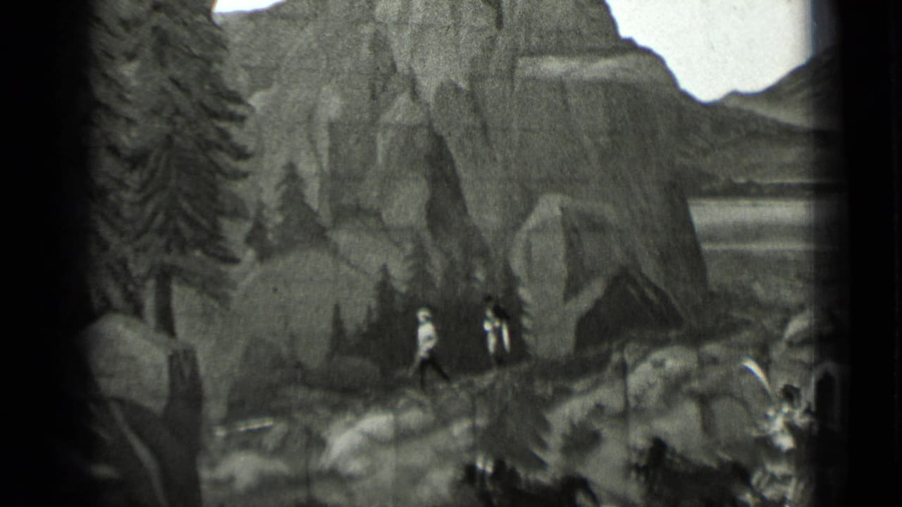 Costumed figures walk near rocks and a painted mountain backdrop.