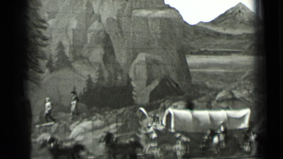 A horse-drawn covered wagon crosses below painted cliffs and hills in the 1937 San Francisco stage scene.