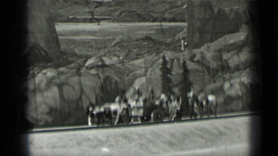 Final 1937 San Francisco frame with oxen, clustered traveler figures, wagon pieces, and a painted mountain exhibit backdrop.