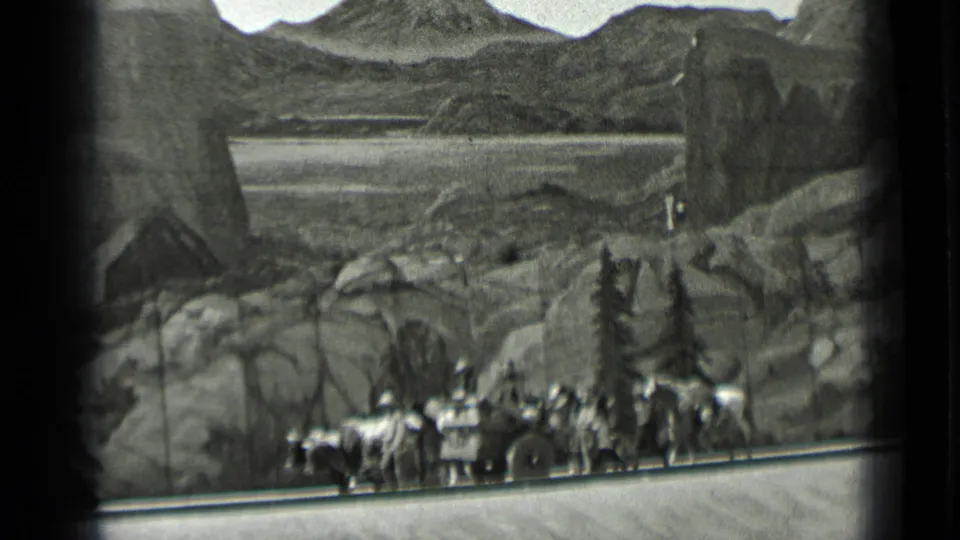 1937 San Francisco 8mm frame showing visitors, horses, and a wagon before a painted rocky mountain scene.