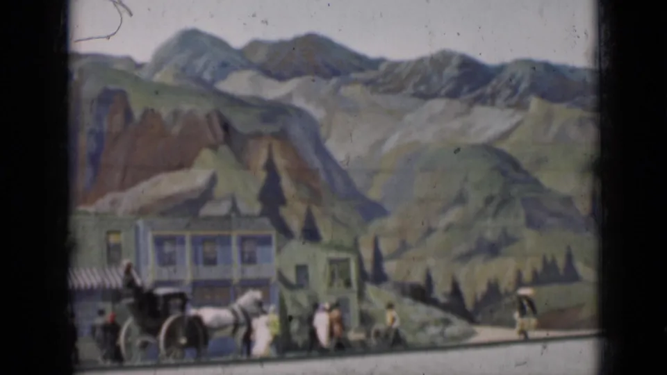 1937 San Francisco home-movie frame showing a carriage and small groups of people before painted buildings and hills.