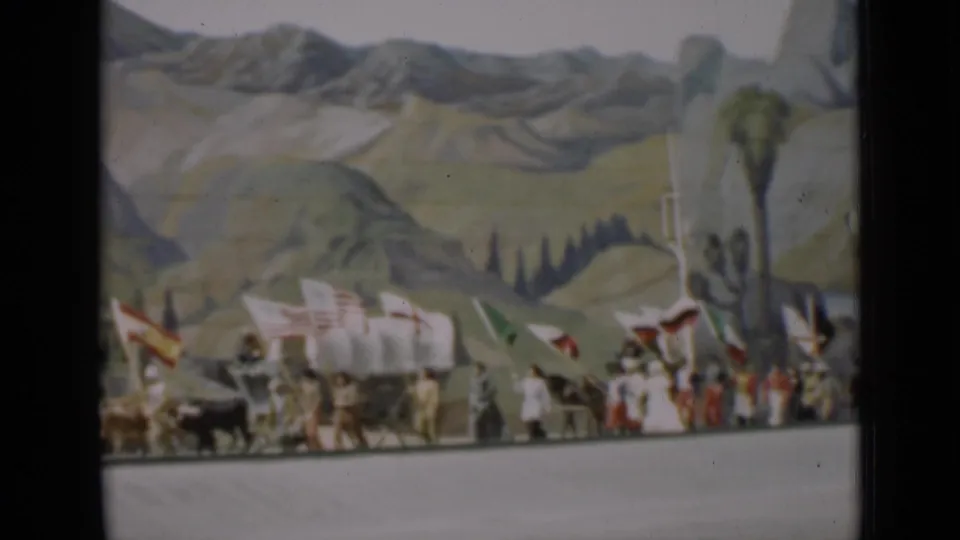 1937 San Francisco parade frame showing a wagon team, marchers, flags, and a tall painted tree in the backdrop.
