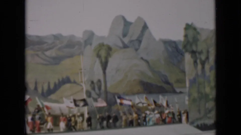 Flag procession continues on a San Francisco stage in 1937, with a U.S. flag and other banners visible against a scenic backdrop.