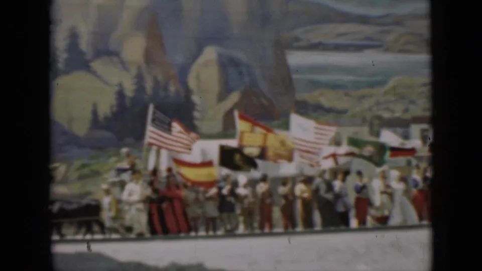 Participants gather with multiple national flags on a 1937 San Francisco stage, backed by a painted landscape scene.