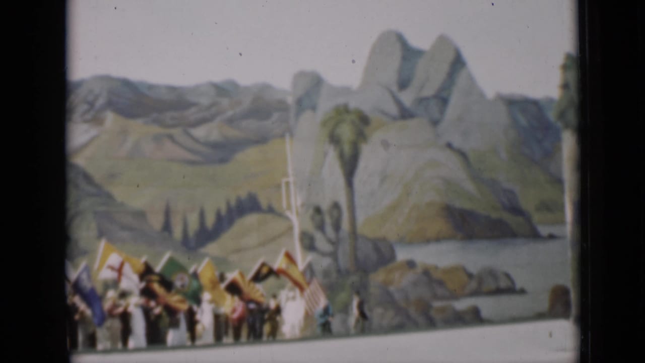 The final frame shows a smaller cluster of flag bearers beside painted mountains, palm-like scenery, and a curved foreground edge.