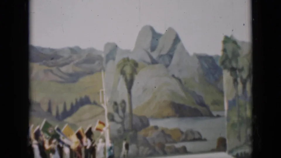1937 San Francisco home-movie frame showing spectators and national flags before a painted mountain-and-lake backdrop.