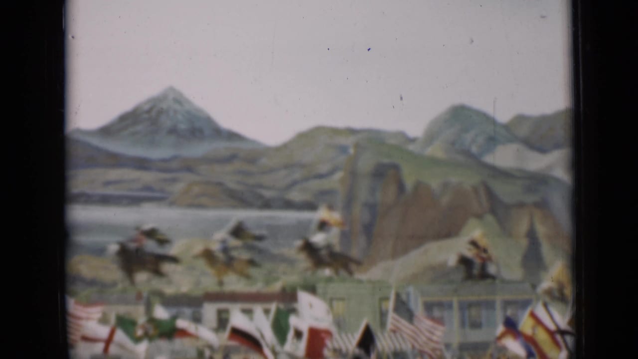 Horseback riders pass across the lower frame while national flags and a scenic painted backdrop define the 1937 San Francisco parade view.