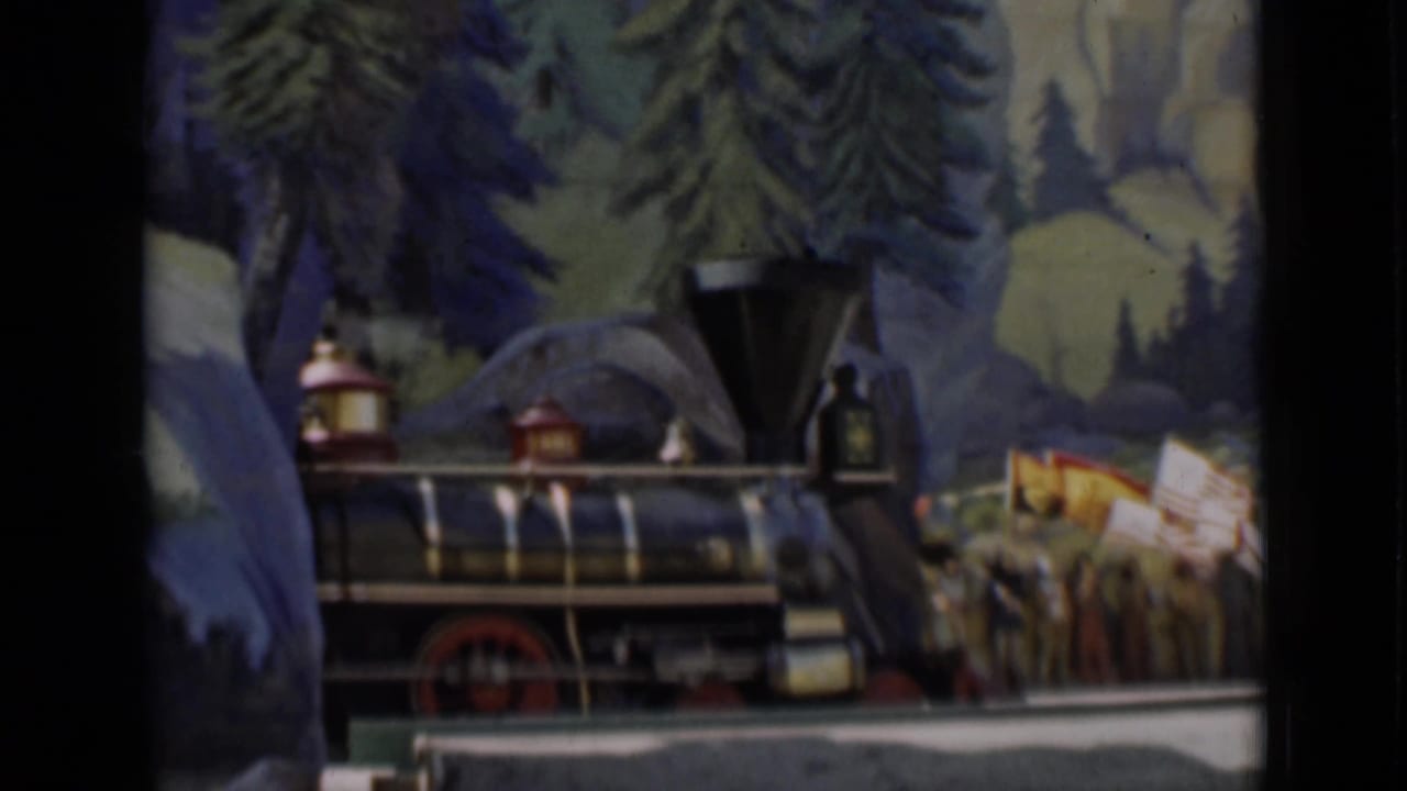 A small steam locomotive display appears beside parade participants and flags in the 1937 San Francisco footage.
