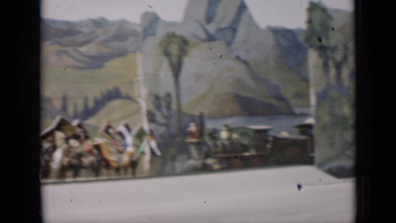 A small train display appears beside the tail of a mounted flag procession in 1937 San Francisco footage.