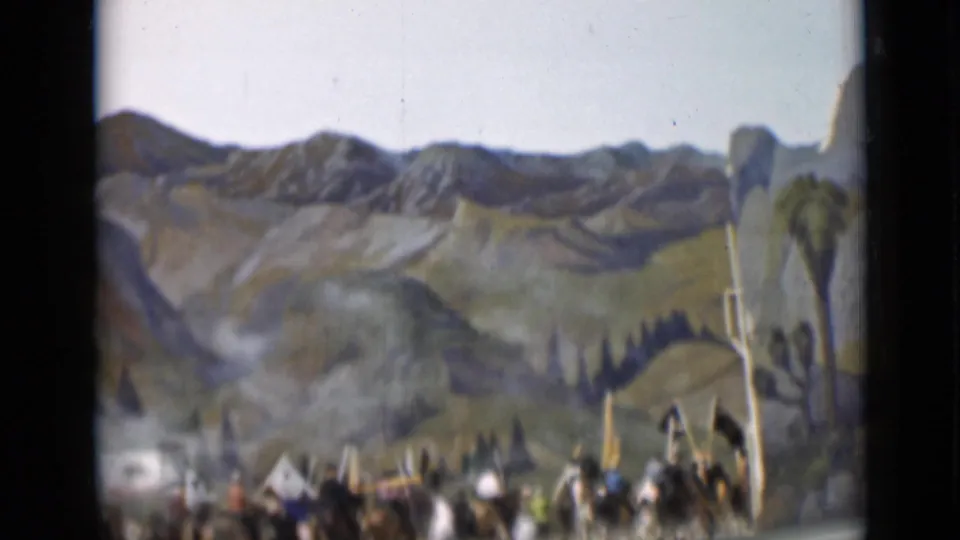 1937 San Francisco parade footage shows a blurred group of riders and flag bearers below a painted hillside and mountain backdrop.