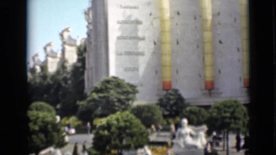 1937 San Francisco exposition view with the Tower of the Sun, ornate buildings, trimmed trees, statues, and visitors in the plaza.
