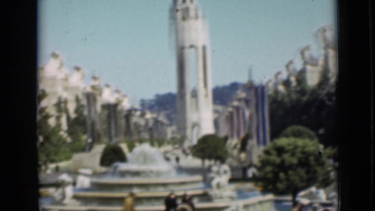 Soft 8mm view of the San Francisco exposition fountain court with the Tower of the Sun, statues, buildings, trees, and visitors.