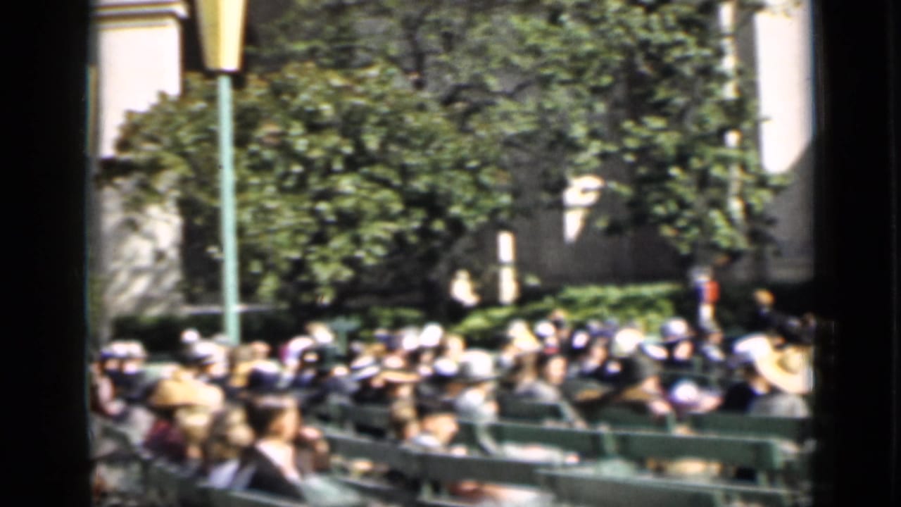 A wider 1937 San Francisco audience view shows spectators on green benches, trees, a lamppost, and the outdoor arena setting.