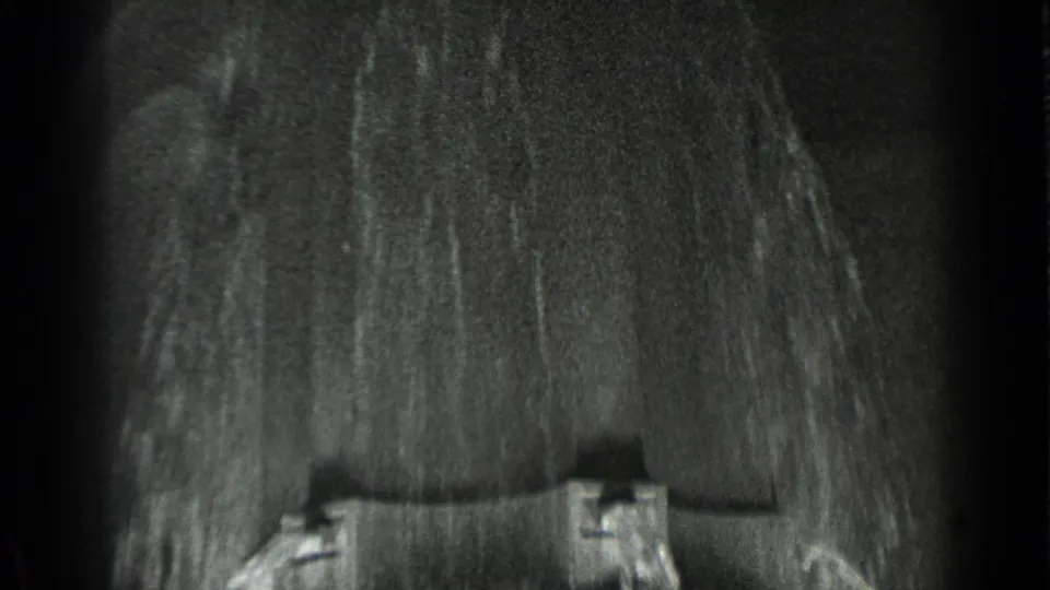 Soft, dark 8mm frame from the 1937 San Francisco clip, showing indistinct textured detail and partial structure near the lower edge.