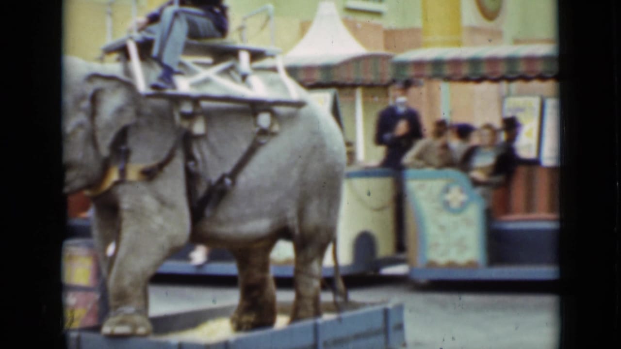 A 1937 San Francisco home-movie frame shows the elephant ride in front of benches, spectators, and the decorated circus-style vehicle.