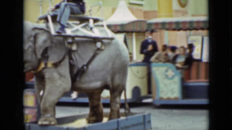 A 1937 San Francisco home-movie frame shows the elephant ride in front of benches, spectators, and the decorated circus-style vehicle.