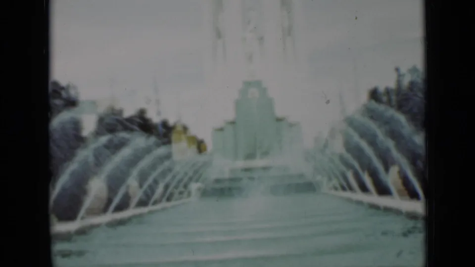 San Francisco 1937 frame with fountain spray crossing a pool and a stepped pale structure centered beyond the water.