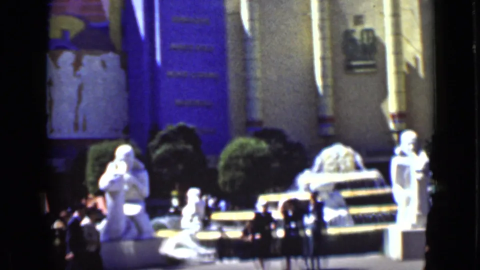 1937 San Francisco home-movie view of statues, visitors, greenery, and a decorated attraction facade from a handheld camera.