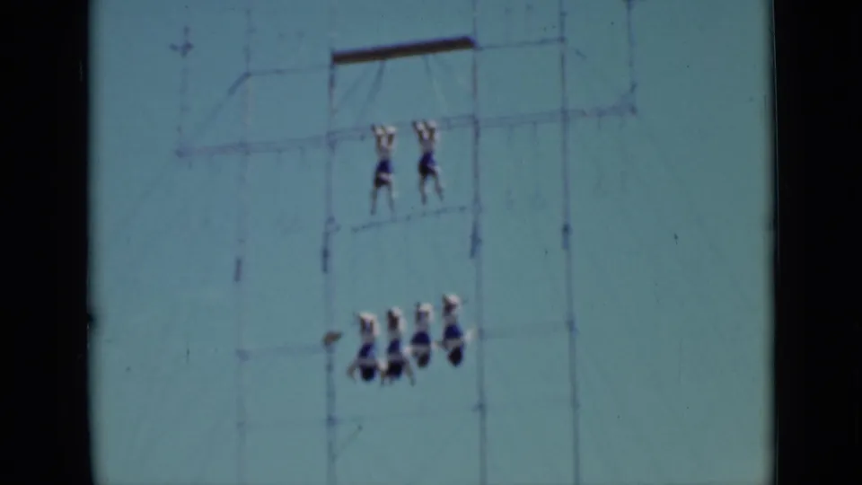 1937 San Francisco 8mm frame showing a lower acrobat group suspended below two performers on high ropes.