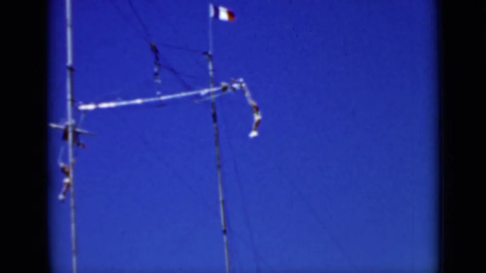 1937 San Francisco home-movie frame showing a trapeze apparatus stretched between tall poles during an outdoor act.