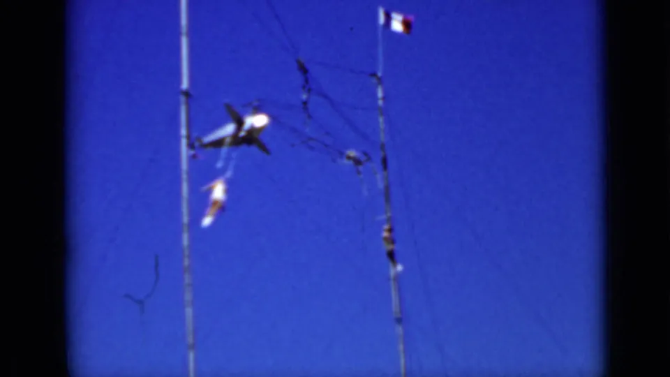 San Francisco 1937 frame showing two aerialists in motion on a high pole-and-rope structure against blue sky.