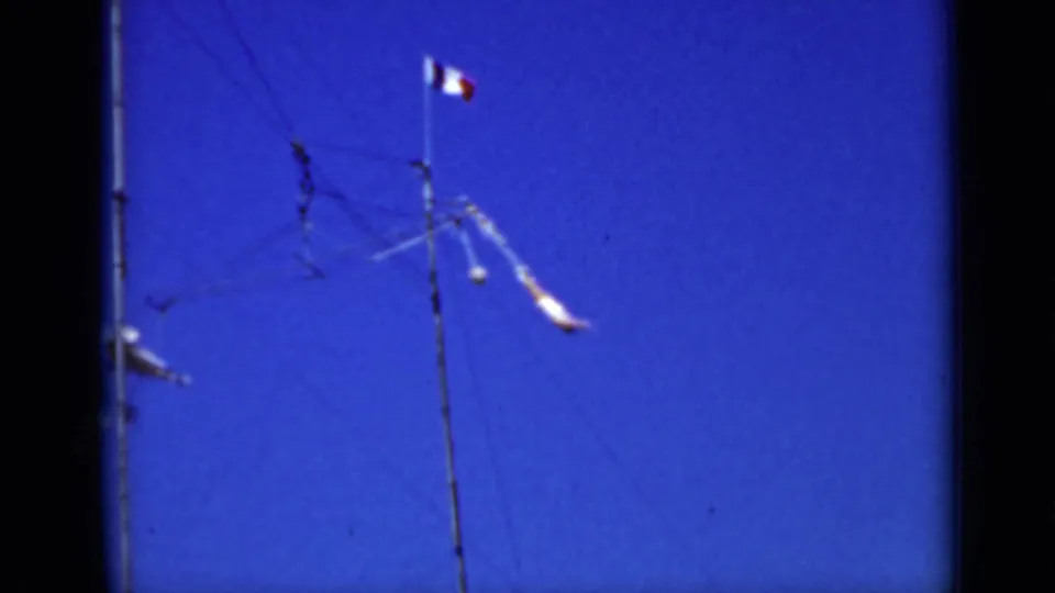 1937 San Francisco frame with a utility pole, thin overhead wires, a small flag, and parts of the suspended airplane mobile.